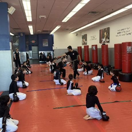 Kids martial arts training with instructor at Tiger Sculmann's Garden City