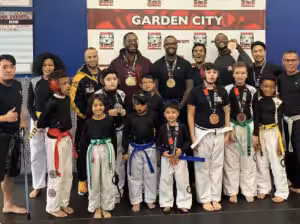 Adult and child fighters with medals standing at Tiger Schulmann's Garden City