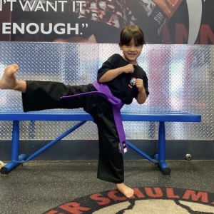 A little girl performing a karate kick at Tiger Schulmann's Glendale