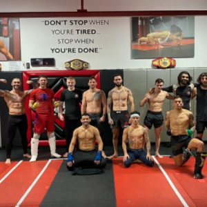 A group of male MMA fighters posing at Tiger Schulmann's Greenpoint