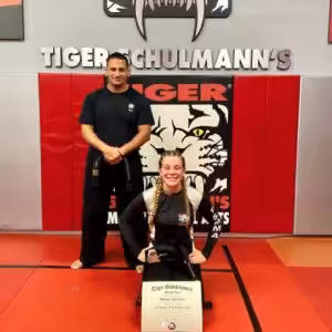 A girl with the certificate with her instructor standing behind in Greenpoint