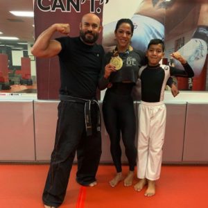 Sensei Matthew Castillo with a woman with a medal and a boy at Tiger Schulmann's