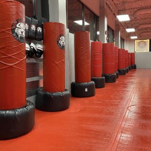 A gym with red floor and red punching bags at Tiger Schulmann's Hauppauge
