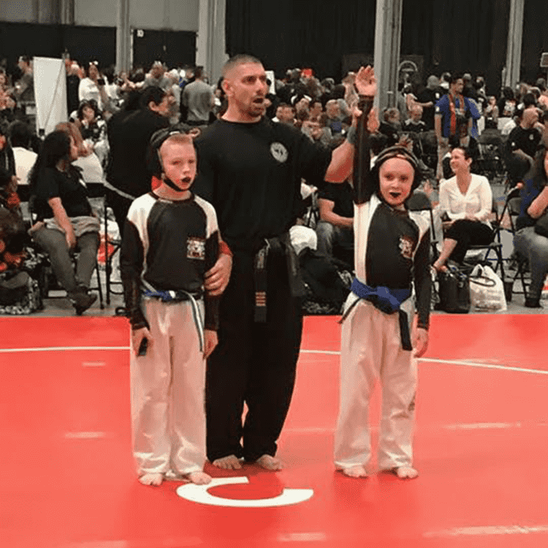 Referee raises boy's arm declaring his victory in Middle Village