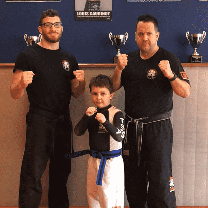 A boy and two martial arts instructors at Tiger Schulmann's New Dorp