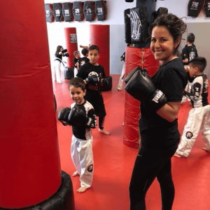Kids training using punching bags with their instructor in New Dorp