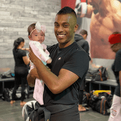 Martial arts fighter holding a baby at Tiger Schulmann's Rockville
