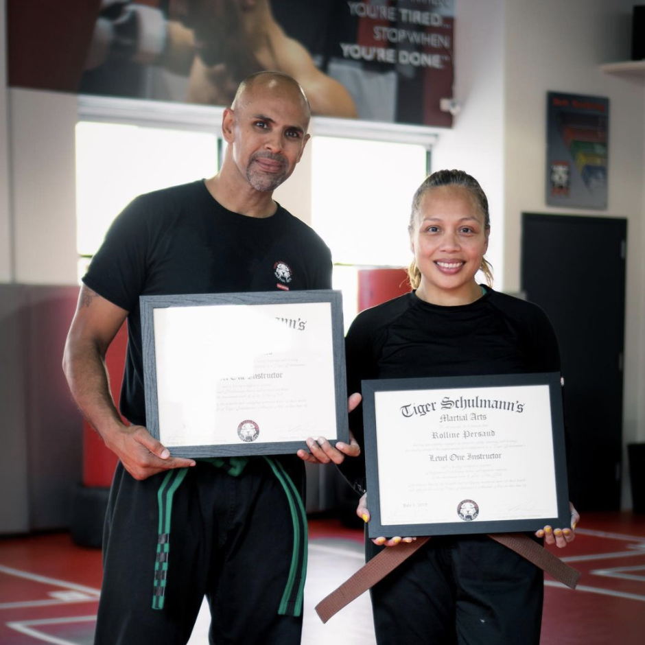 A man and a woman fighters showing their level one instructor cetrificates