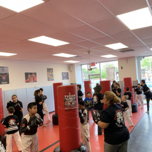 Adults and kids workout with punching bags at Tiger Schulmann's Middle Village