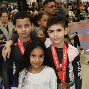Two boys with medals and a little girl at Tiger Schulmann's Middle Village