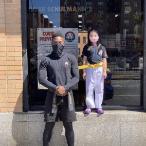 Martial arts fighter and a little gild outside of Tiger Schulmann's Rego Park