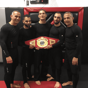 Five martial arts fighters showing a championship belt in Tottenville