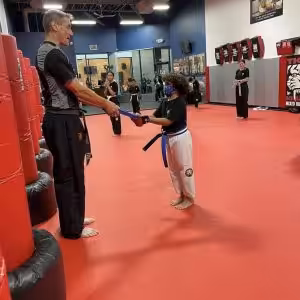 Kid receiving a blue belt at Tiger Schulmann's Wayne