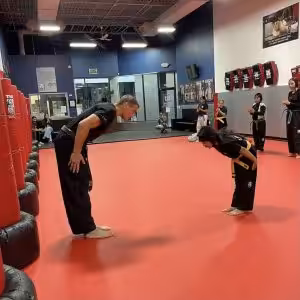 Martial arts instructor and a little girl bowing in Wayne