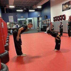 Martial arts instructor and a little girl bowing in Wayne
