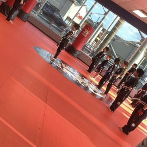 Kids martial arts training on the red floor at a gym