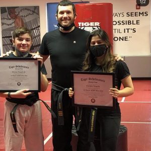 Sensei with a boy and a girl with their MMA certificates
