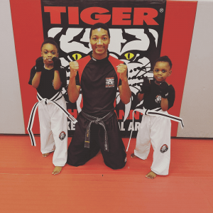 Instructor and two little girls with fists up