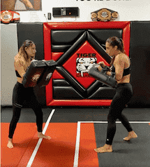 Two women sparring during kickboxing workout