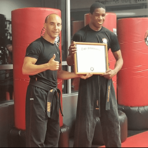 Two adult martial arts fighters showing a certificate