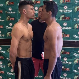 Two martial artfighters face to face with green wall behind