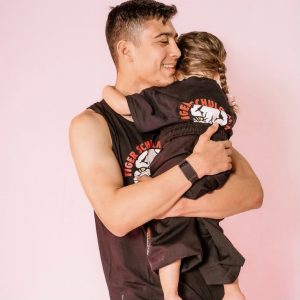 Man holding a little girl in Tiger Schulmann's outfit