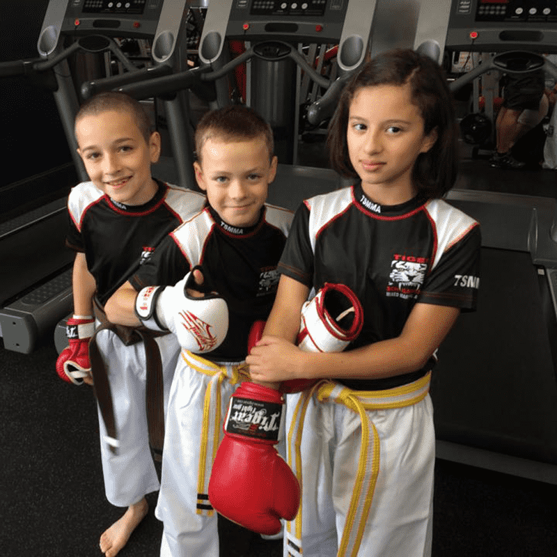 A girl and two boys in MMA gear