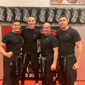 Four kickboxers in black shirts at Tiger Schulmann's in Ramsey