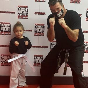 Martial arts instructor and a little girl with fists up at Tiger Schulmann's in Red Bank