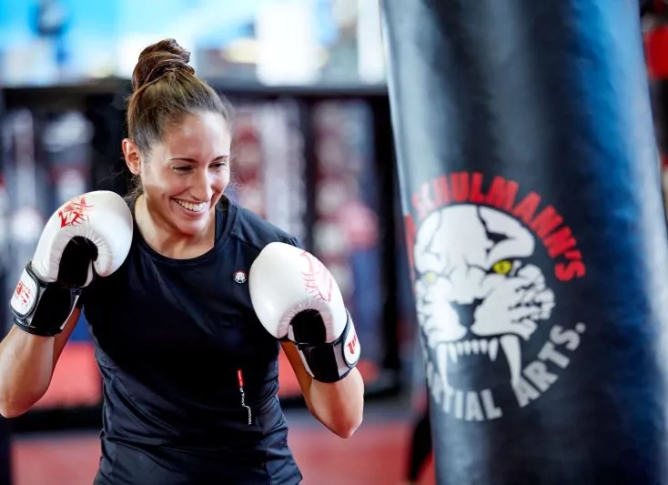 Woman kickboxer smiling and getting ready to punch the bag