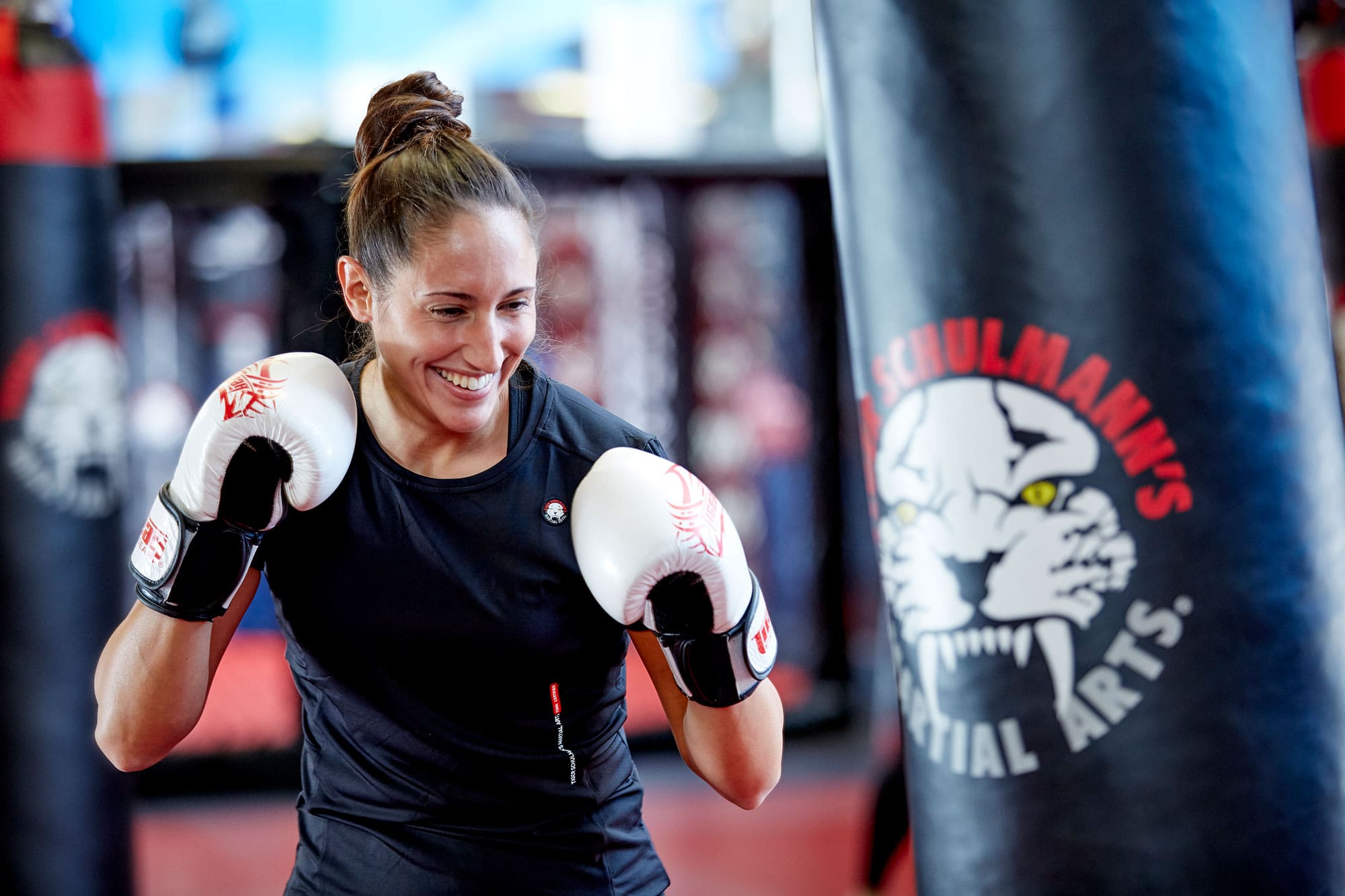 Woman kickboxer smiling and getting ready to punch the bag