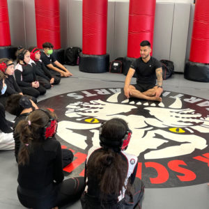 UFC fighter holding a lecture to kids in a gym in Middle Village