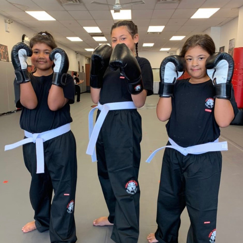 Three little girls posing in a boxing stance in Middle Village