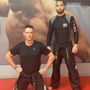 Two men posing in a training facility