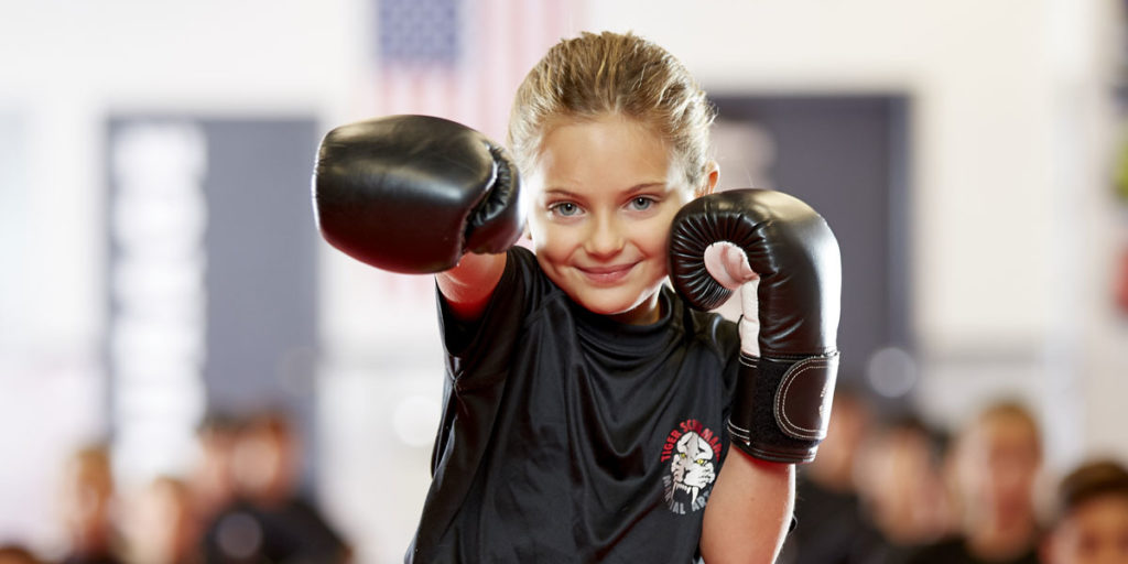 A little girl smiling and posing during kids karate class at Tiger Schulmann's martial arts