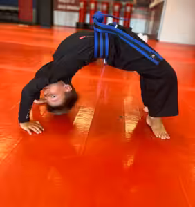 A boy performing bridge exercise at Tiger Schulmann's Eatontown