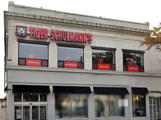 A two-story building with a sign reading "TIGER SCHULMANN'S" in red letters above the second-floor windows.