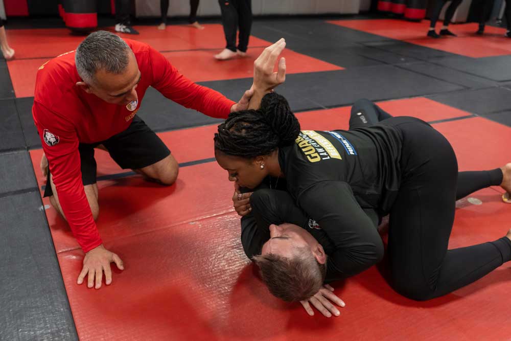 A woman and a man grappling on the floor as a part of the Law Enforcement tactics training at Tiger Schulmann's Martial arts
