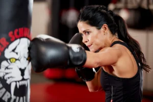 Woman punching a bag during kickboxing cardio workout at Tiger Schulmann's