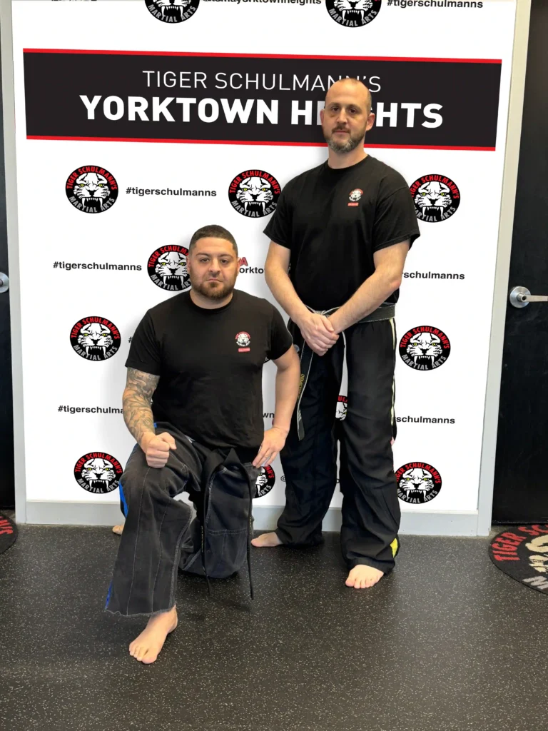 Sensei Demetrius standing with Joshu Rascona kneeling at Tiger Schulmann's Yorktown heights